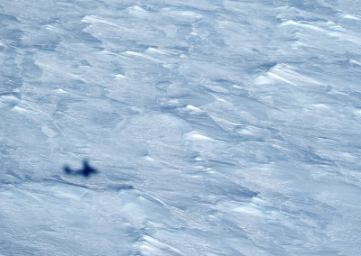 Rough ice surface with aircraft shadow.